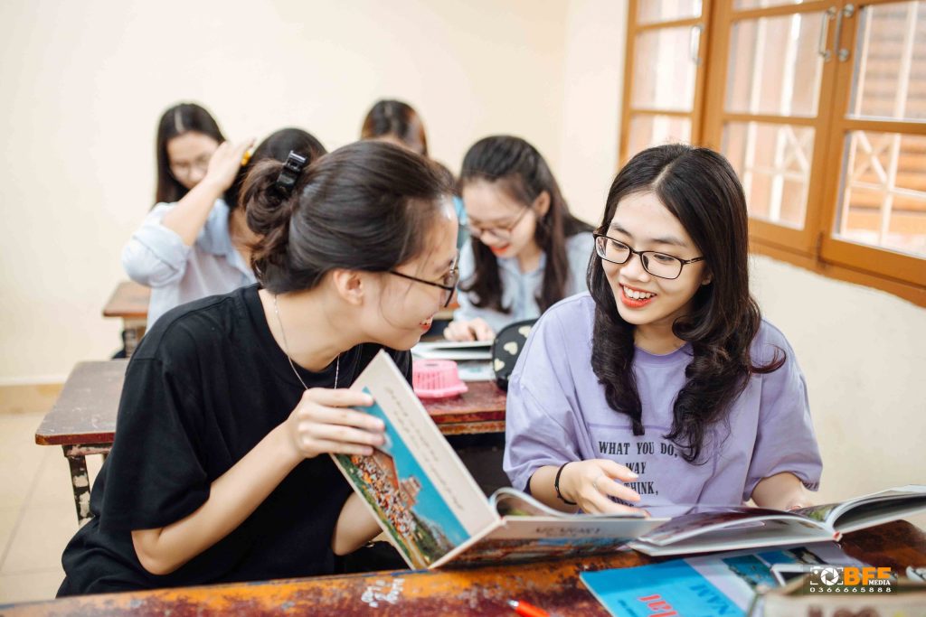 Các bạn học sinh cùng xem album ảnh kỷ yếu trong lớp học