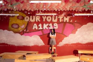 Nữ sinh chụp kỷ yếu trước tường Our Youth A1K19 vẽ mây hồng trên nền đỏ