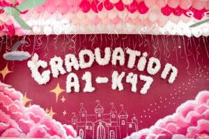 Cận cảnh chữ bông Graduation A1-K47 trên tường lớp kỷ yếu nền hồng đỏ