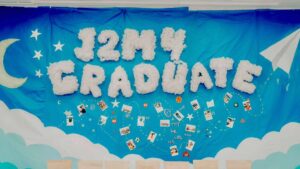 Tường kỷ yếu J2M4 Graduate chữ bông trắng, trăng lưỡi liềm và sao trên nền xanh