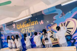 Học sinh đang vẽ tường trang trí lớp kỷ yếu Graduation D7K2 tông xanh tím