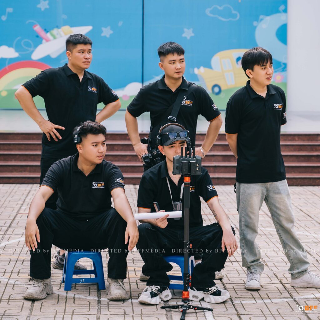 Ekip chụp ảnh kỷ yếu BFFMEDIA trong đồng phục, chuẩn bị máy móc trước buổi chụp tại sân trường