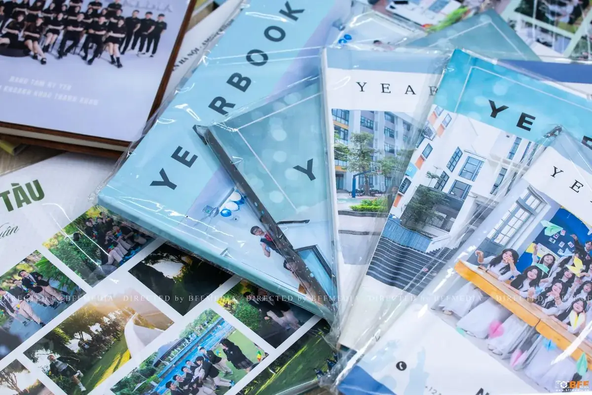 Chồng quyển yearbook kỷ yếu bọc túi nilon xếp cùng loạt ảnh in rời