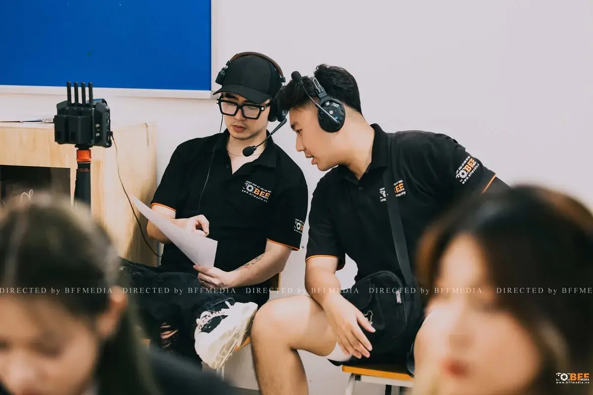 Hai thành viên ekip BFFMEDIA kiểm tra ảnh trên màn hình trong buổi chụp kỷ yếu