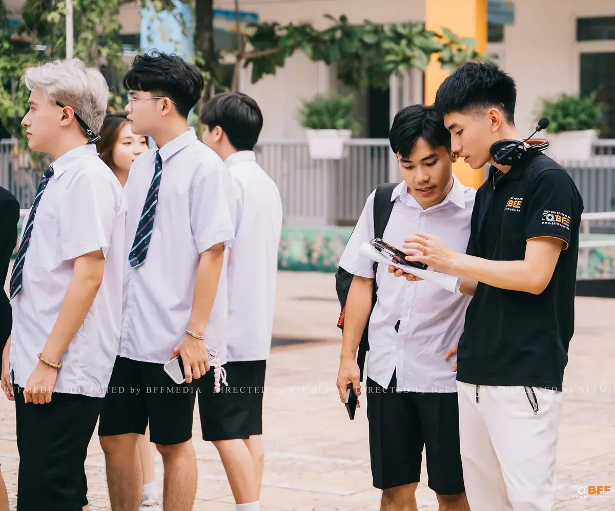 Học sinh và ekip BFFMEDIA xem lại ảnh vừa chụp trên điện thoại ngay tại sân trường