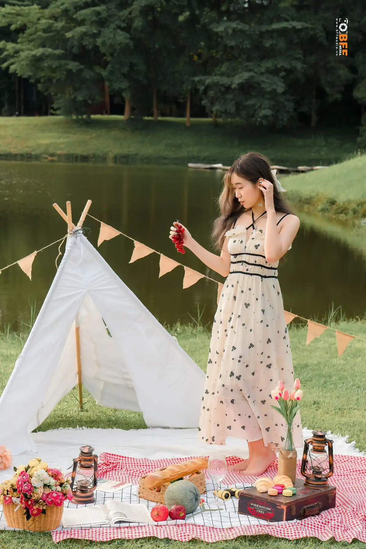Nữ sinh mặc váy hoa tạo dáng bên lều picnic trong buổi chụp kỷ yếu