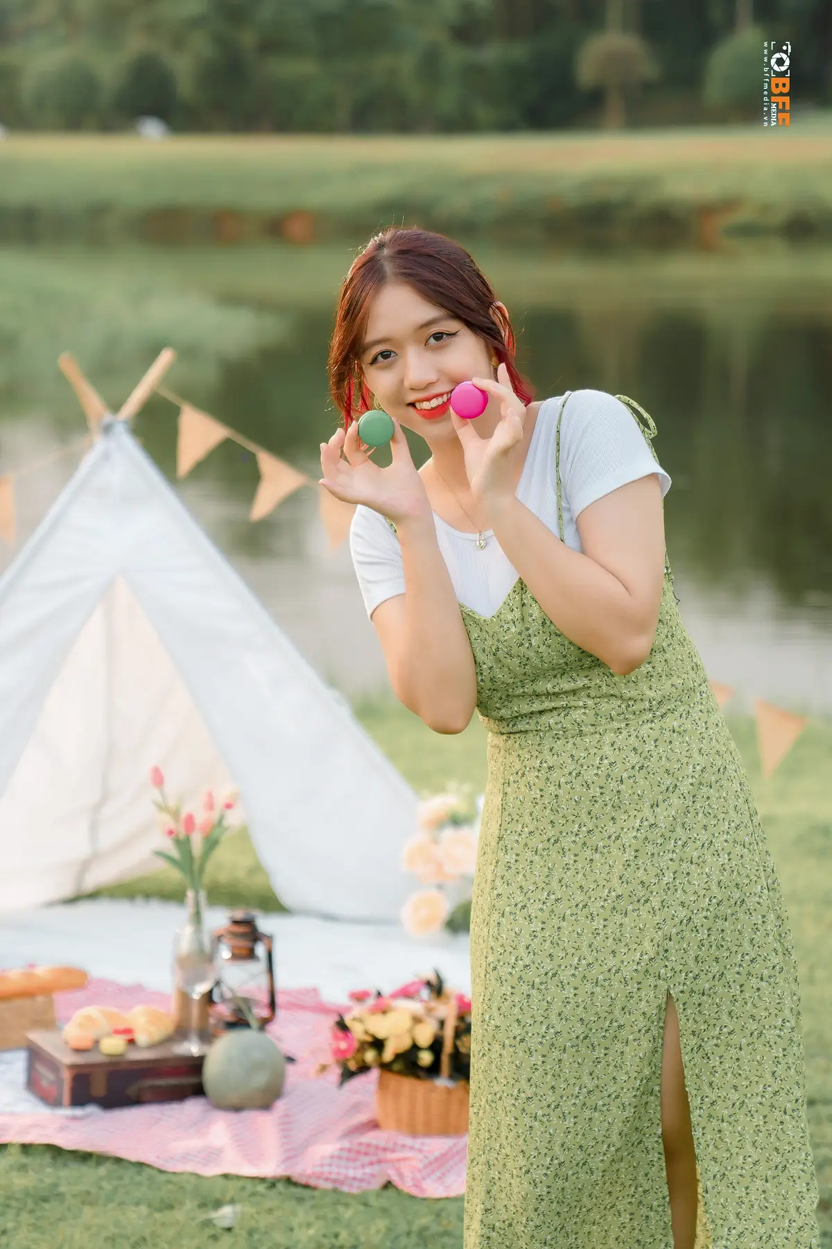 Nữ sinh váy xanh tạo dáng cầm trái cây che mặt khi chụp kỷ yếu