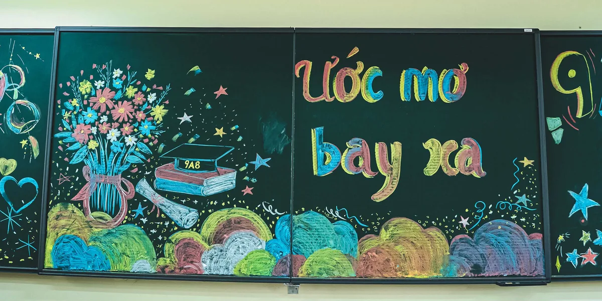 Bảng lớp vẽ phấn màu dòng chữ Ước mơ bay xa và tên lớp 9A8