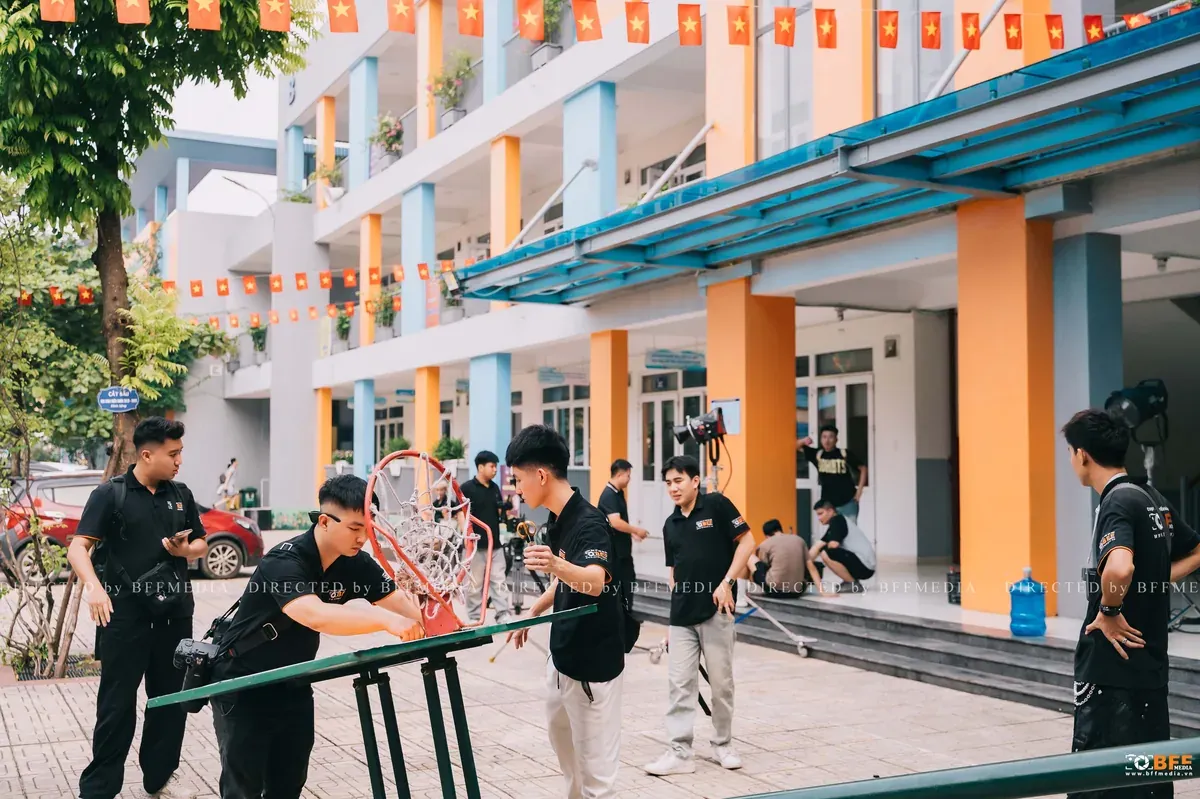 Ekip chụp kỷ yếu dựng đèn và đạo cụ trên sân trường trước giờ chụp